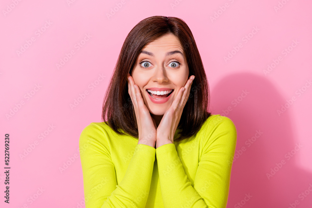 Photo of astonished impressed girl arms touch cheeks toothy smile isolated on pink color background Photo of astonished impressed girl arms touch cheeks toothy smile isolated on pink color background