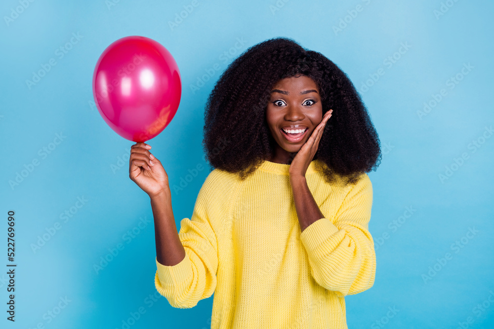 Photo of nice adorable gorgeous girl with wavy hairdo wear yellow jumper hold hand on cheek balloon isolated on blue color background Photo of nice adorable gorgeous girl with wavy hairdo wear yellow jumper hold hand on cheek balloon isolated on blue color background
