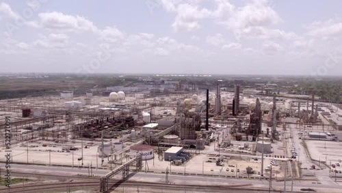 Aerial Shot Of Oil Refinery Industries Under Cloudy Sky, Drone Flying Forward On Sunny Day -  Beaumont, Texas photo