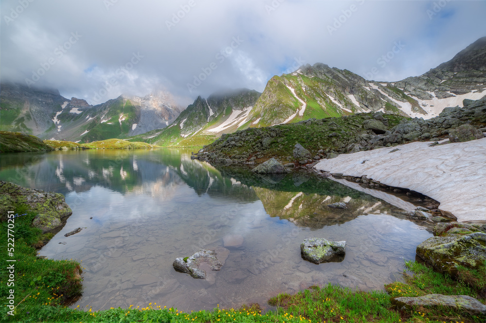 Lake against the backdrop of a mountain range. Photo from a wide angle. Soft focus on mountains.