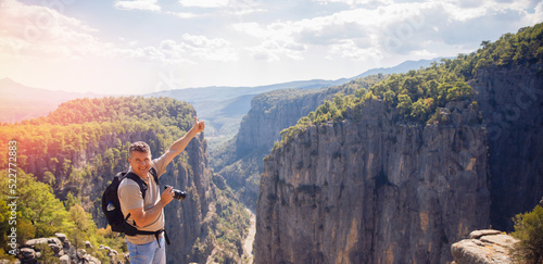 Happy man stands with backpack on background of sunset in mountain Tazi canyon in Manavgat Antalya Turkey