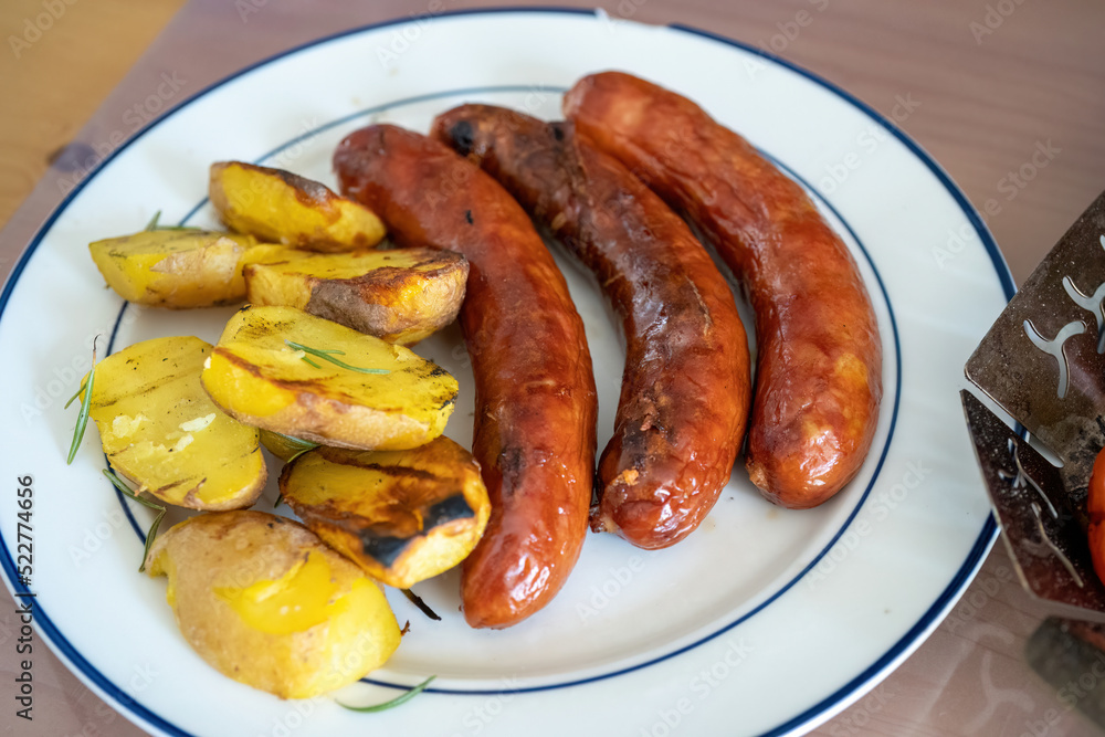 ready to eat - grilled cheese kransky and potatoes from a outdoor charcoal grill ready to eat - grilled cheese kransky and potatoes from a outdoor charcoal grill