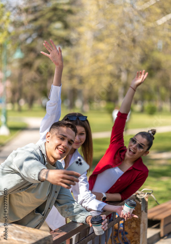 Group of three tourist friends taking selfie with smart phone