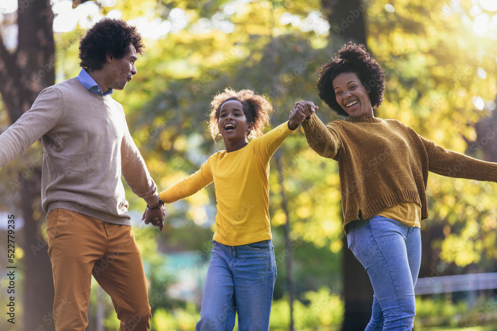 Happy family mother father and daughter on autumn walk in the park Happy family mother father and daughter on autumn walk in the park