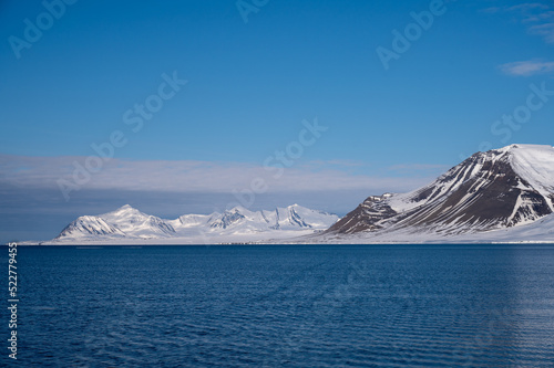 Views of the coast of Svalbard with mountains, ice and ocean in the sunshine