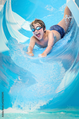 Konstfotografi joyful boy going down the water slide in the water park, Alanya, Antalya, Turkey
