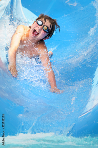 Konstfotografi joyful boy going down the water slide in the water park, Alanya, Antalya, Turkey