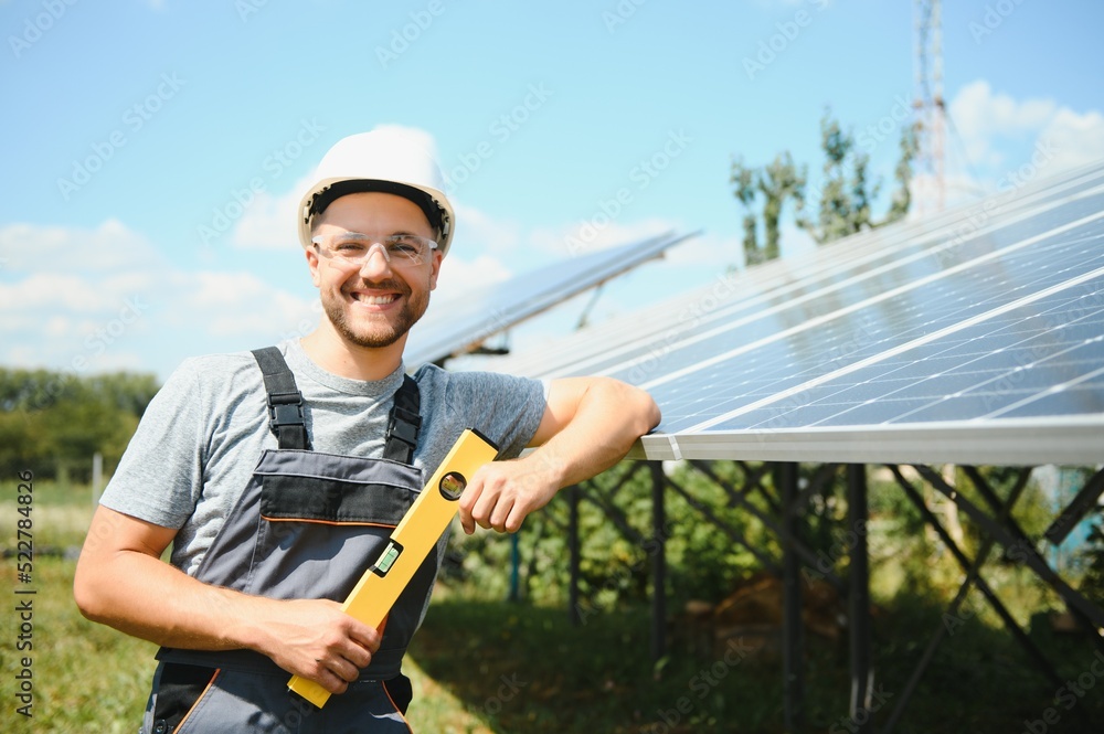 Worker installing solar panels outdoors Worker installing solar panels outdoors