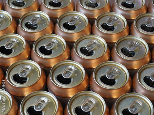 Empty open drink cans in golden color, top view background image