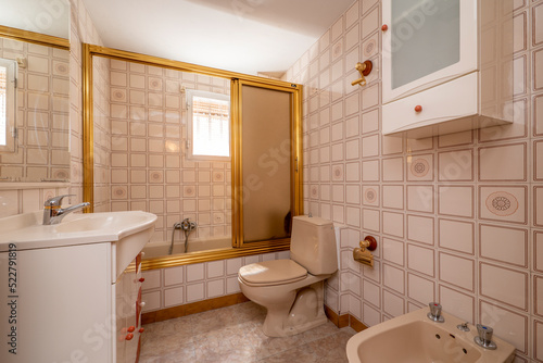 Bathroom with large shower with gold-edged glass partition  mirror with fine white frame and matching porcelain sink