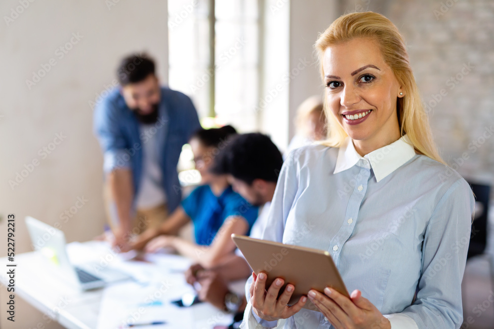 Fototapeta premium Portrait of happy successful business people working on tablet in office. Business teamwork concept