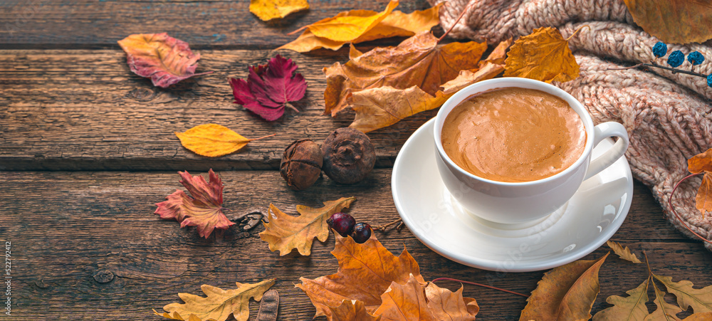 Coffee mug and autumn foliage on a wooden background. Cozy autumn composition. Side view, copy space Coffee mug and autumn foliage on a wooden background. Cozy autumn composition. Side view, copy space