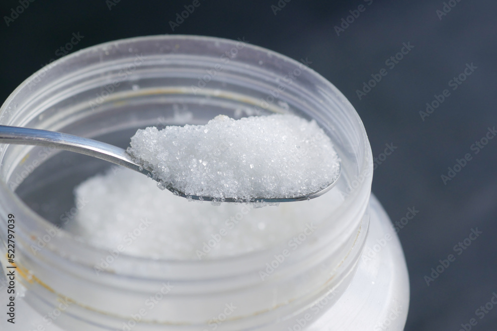 white sugar and spoon in a container on black background, white sugar and spoon in a container on black background,