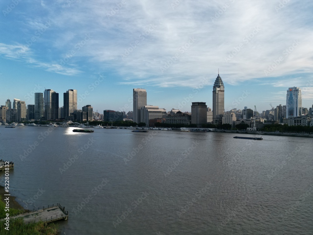 Flying with a drone over the Huangpu in Shanghai and taking in the views of the Bund with the sunset in the backdrop