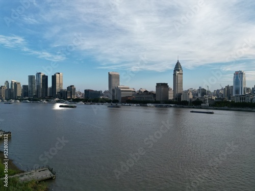 Fototapeta Naklejka Na Ścianę i Meble -  Flying with a drone over the Huangpu in Shanghai and taking in the views of the Bund with the sunset in the backdrop