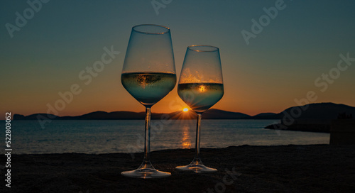 sunset at the ramparts of alghero city with silhouette with two glasses of prosecco 