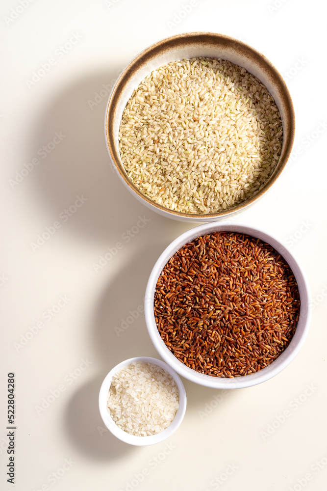 Uncooked rice assortment in bowl on white background. Top view. Uncooked rice assortment in bowl on white background. Top view.