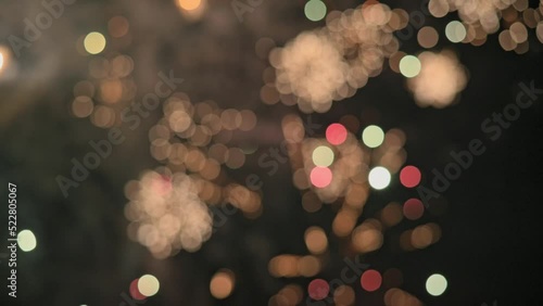 Blurred bokeh. Bright colorful festive glowing fireworks on dark night sky. New Year, Christmas, festival, party, holiday celebration. Fireworks background, real footage 4K