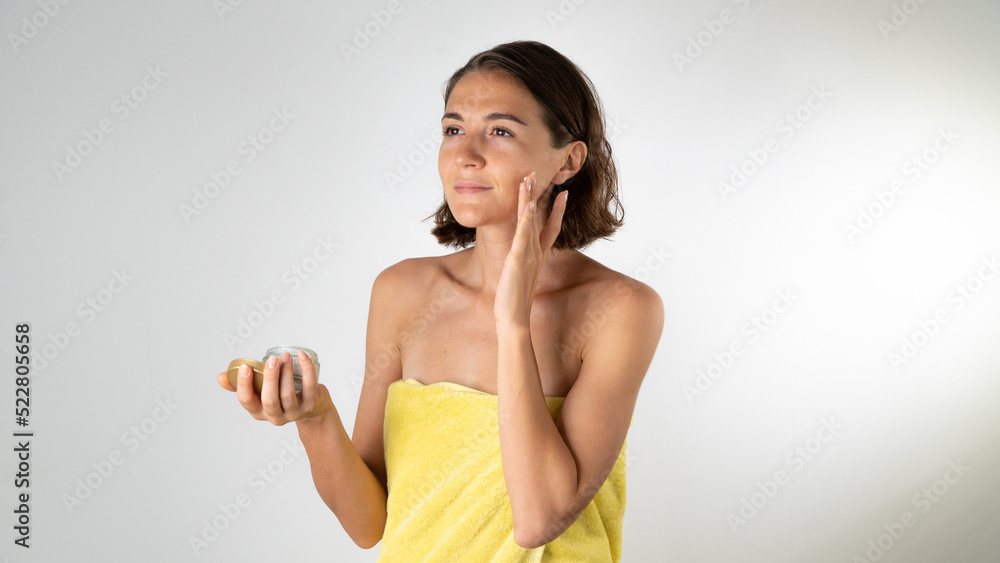 A woman applies the cream on the face - spa at home A woman applies the cream on the face - spa at home