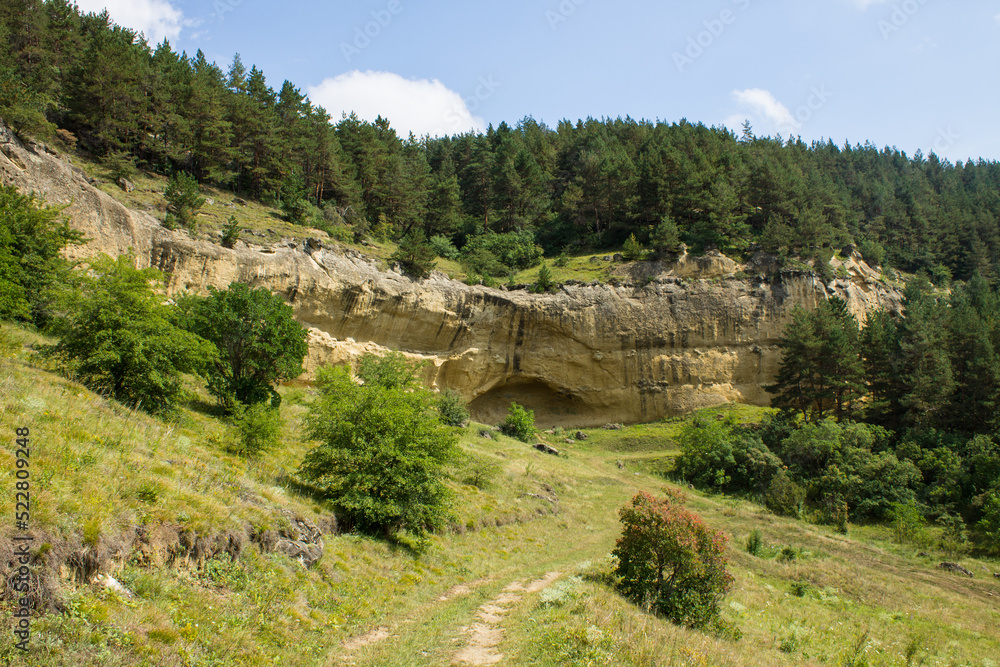 Beautiful landscape with steep cliffs and green trees on a sunny summer day in the vicinity of Kislovodsk russia