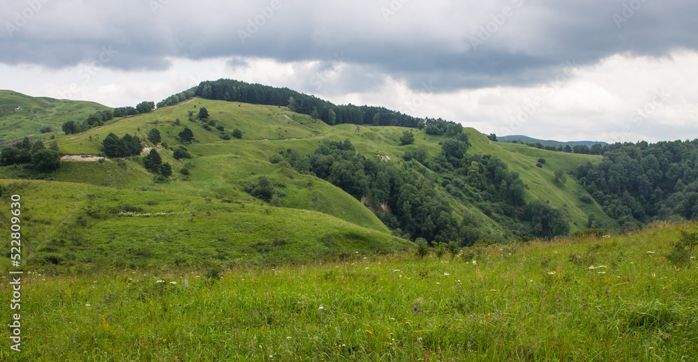 Obraz premium landscape - panoramic view of the hills and green valley from the Maloe Sedlo mountain in Kislovodsk Russia on a cloudy summer day