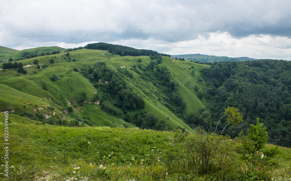 landscape - panoramic view of the hills and green valley from the Maloe Sedlo mountain in Kislovodsk Russia on a cloudy summer day