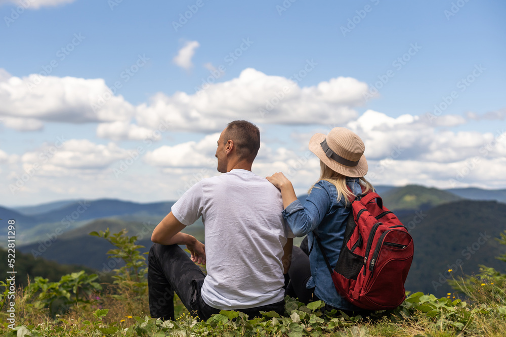 Portrait of beautiful young couple enjoying nature at mountain peak.