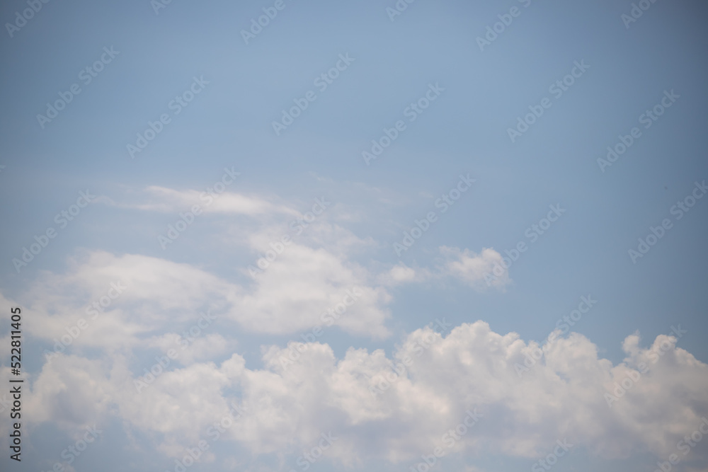 Light blue sky and white clouds. Peaceful sky background.