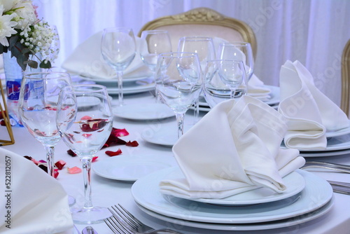 Decorated wedding table with silverware dishes and flower center piece. photo