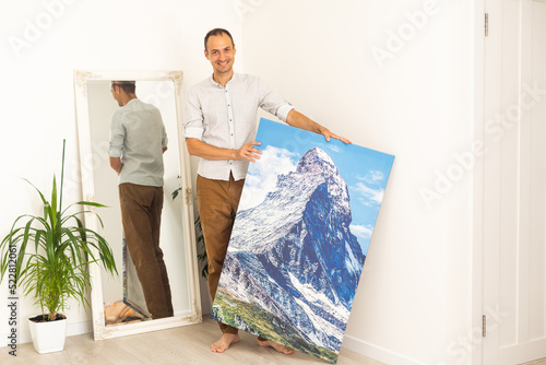 Modern Home Interior And Domestic Decor. a man is holding a photo canvas