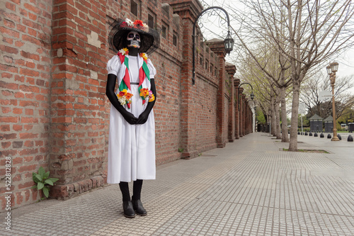 A woman standing and dressed as La Calavera Catrina, traditional mexican female skeleton
