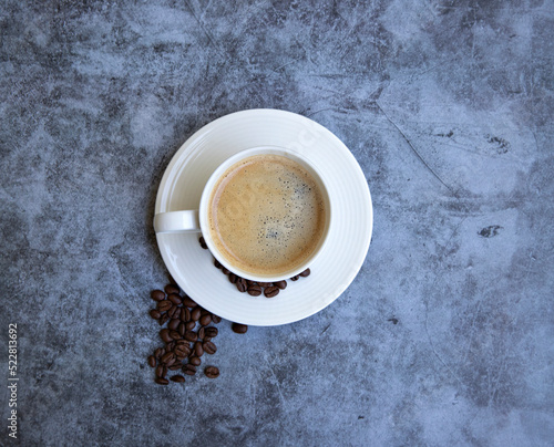 cup of coffee with grains on a gray background 