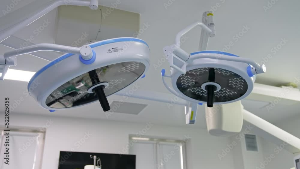 Switched off big lamps in modern surgical room. Equipment of present day operational theatres from low angle view. Switched off big lamps in modern surgical room. Equipment of present day operational theatres from low angle view.