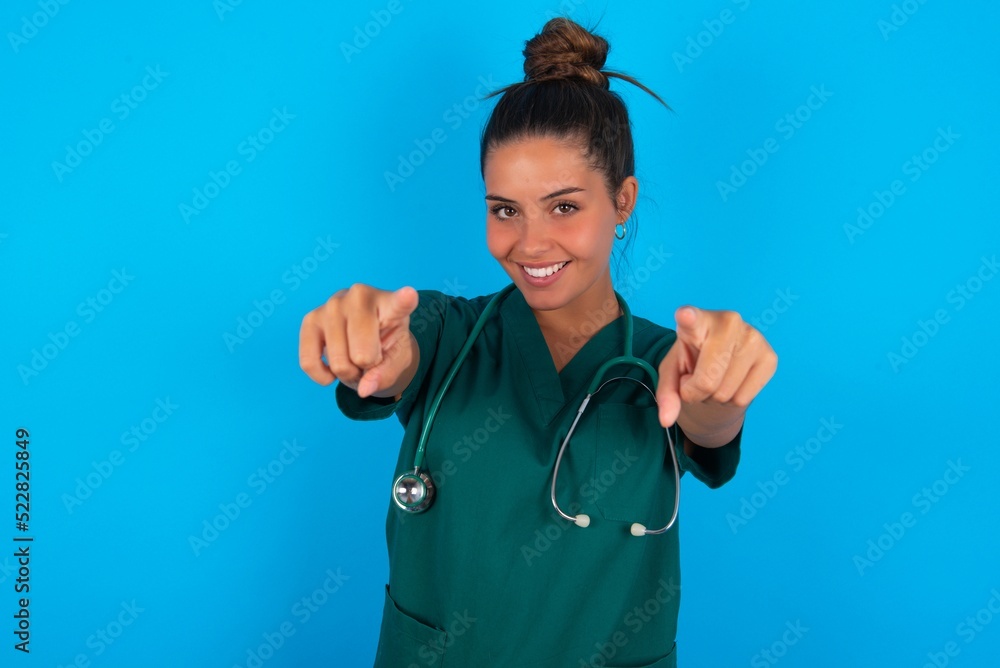 beautiful doctor woman wearing medical uniform over blue background cheerful and smiling poiting at camera beautiful doctor woman wearing medical uniform over blue background cheerful and smiling poiting at camera