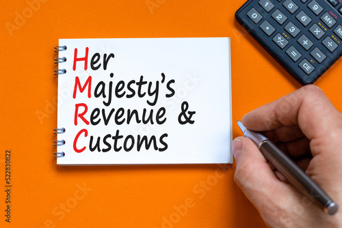 HMRC her majestys revenue and customs symbol. Concept words HMRC her majestys revenue and customs on white note on beautiful orange background. Business HMRC revenue and customs concept. Copy space. photo