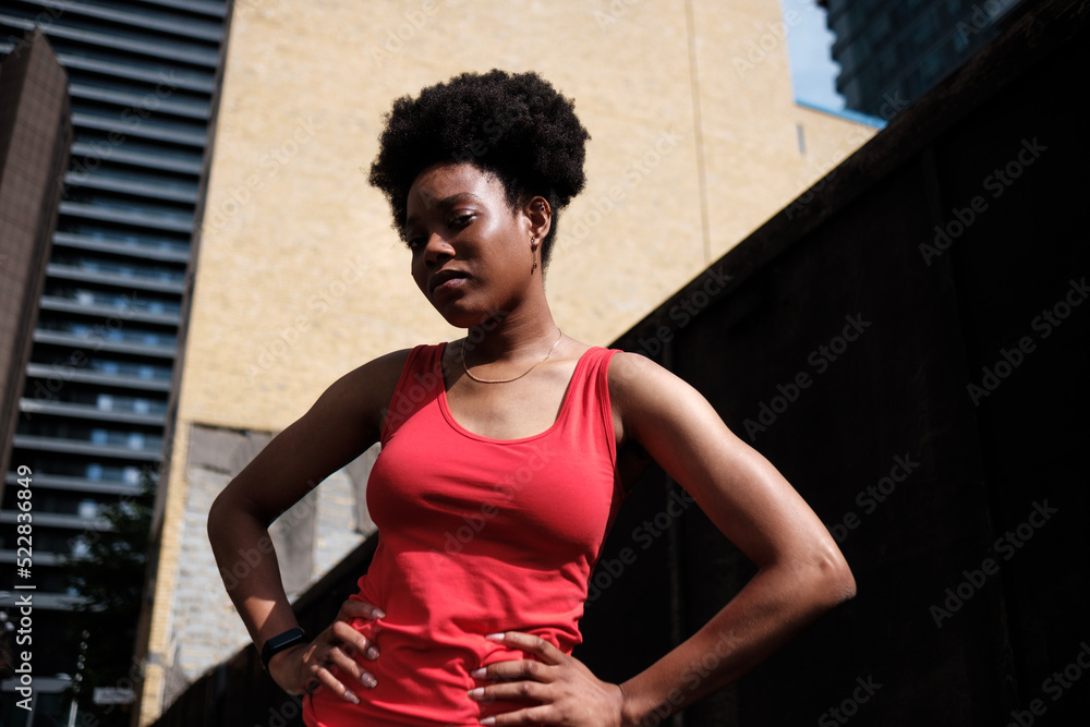 Fototapeta premium Portrait of fit young black woman doing exercise in a street of London.