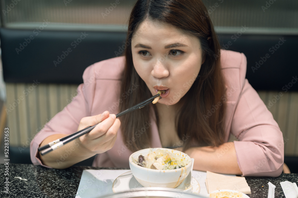 Closeup focus Asian woman using chopsticks to clip the noodles into mouth Closeup focus Asian woman using chopsticks to clip the noodles into mouth