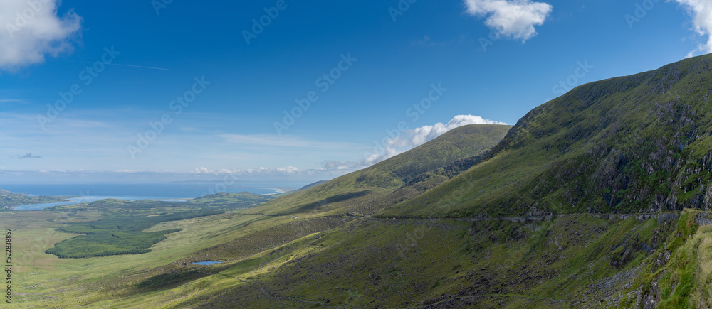 panorama landscape with the steep and winding mountain road leading to the top of Connor Pass on the Dingle Peninsula
