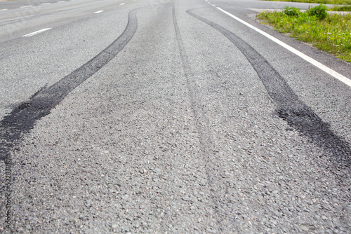 Burnouts on the asphalt made with a powerful muscle car. Skidmark or brake marks due to slippery road or accident. Dangerous driving or accident concept image.