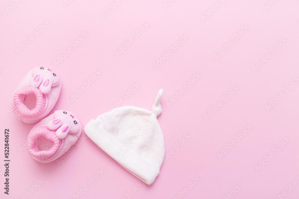 booties in the form of hares and a cap for a baby on a pink background with copy space booties in the form of hares and a cap for a baby on a pink background with copy space
