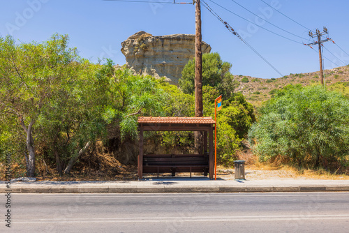 Fototapeta Naklejka Na Ścianę i Meble -  Beautiful view of standard bus stop on island of Rhodes in Greece against backdrop of beautiful mountain landscape. Greece. Rhodes.