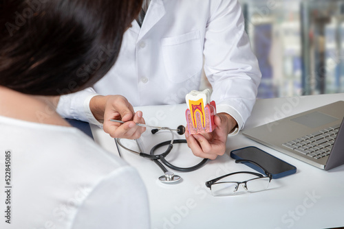 Doctor consulting a female patient about dental diseases .
