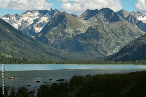 The smooth surface of a glacial lake at the foot of the Altai Mountains in the Katunsky Reserve photo