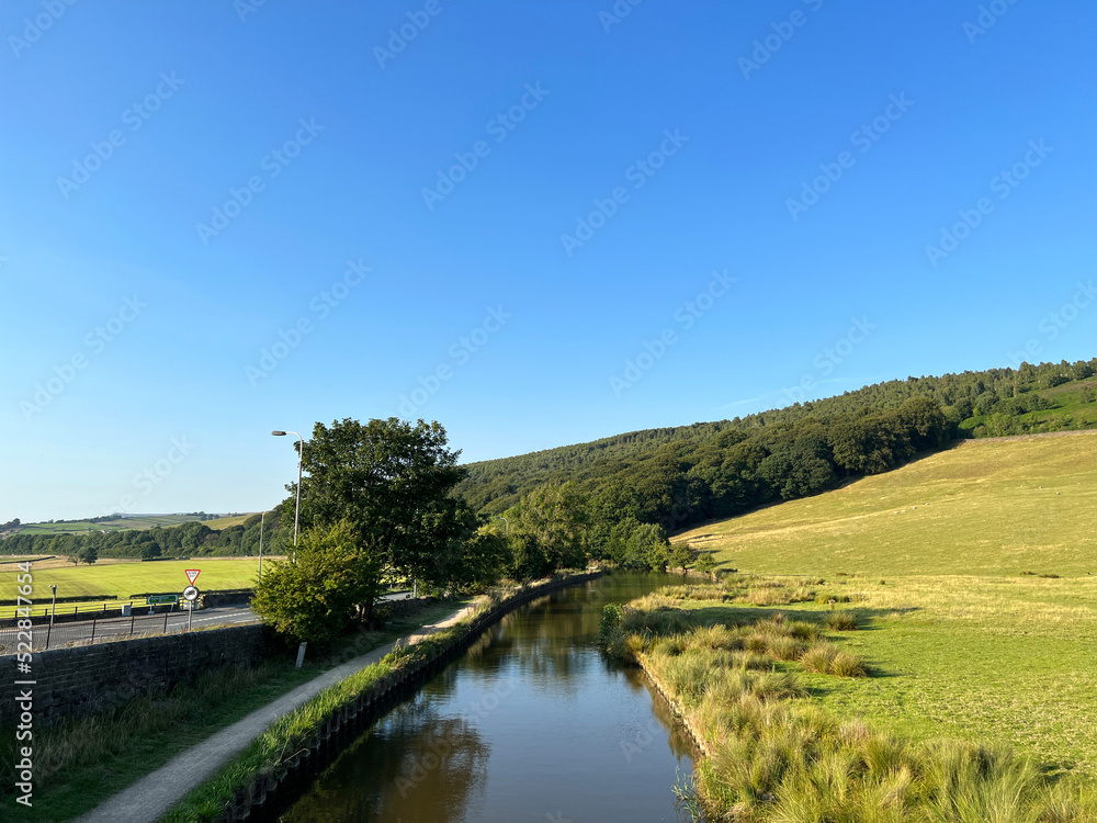 Late evening view, over the Leeds and Liverpool canal, in Farnhill, as it winds its way toward Skipton, Yorkshire, UK