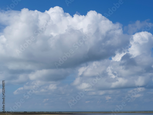 Huge cumulus clouds over the horizon. Clouds in a blue sky, natural texture. Blue sky background with lots of clouds