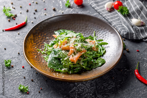 mixed salad with salmon, spinach and aragula on grey table