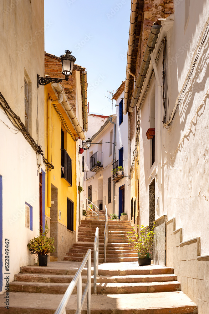 Vertical photo of a view on a little curving street with a stairway going up