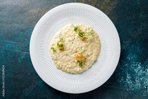 Φωτογραφία risotto with scallops and truffle oil on white plate top view