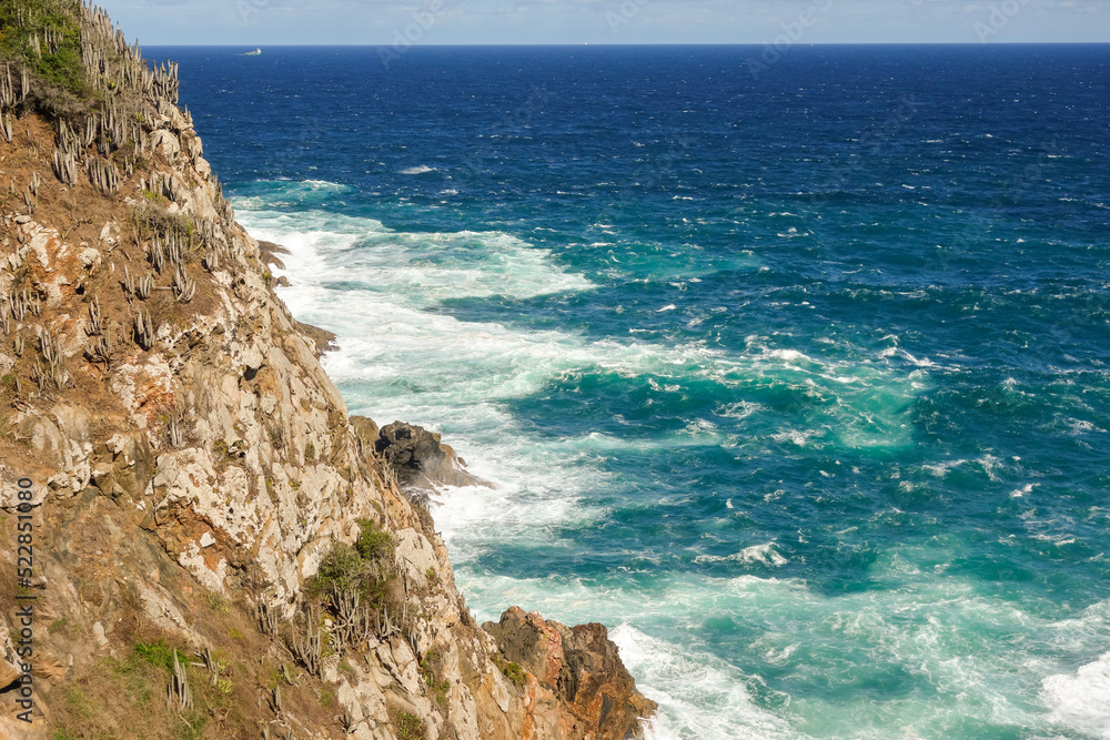 Obraz premium rough sea waters crash violently against rock cliff on the coast