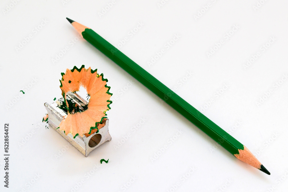 green graphite pencil for drawing and pencil sharpener on a white background green graphite pencil for drawing and pencil sharpener on a white background